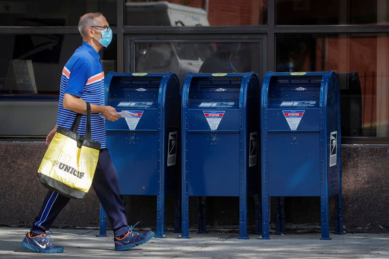 FILE PHOTO: A man carries letters into a USPS post office in Brooklyn, New York