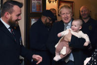 Britain' Prime Minister Boris Johnson holds a baby as he meets with supporters at the Lych Gate Tavern in Wolverhampton, England, Monday, Nov. 11, 2019 as part of the General Election campaign trail. Britain goes to the polls on Dec. 12. (Ben Stansall/Pool Photo via AP)