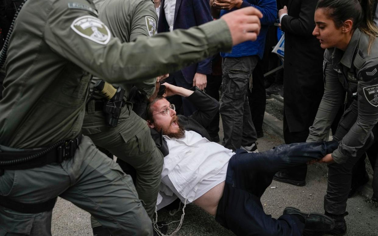 Police officers in Jerusalem struggle with ultra-Orthodox males blocking a road during a protest against Israel's military draft on February 26.