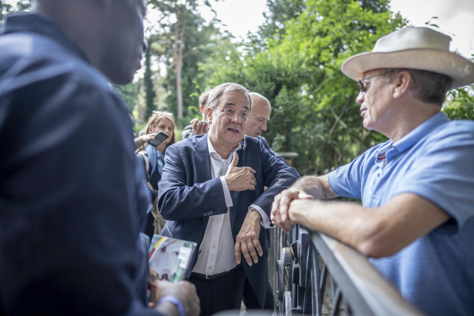 Armin Laschet, center, top canditate of the German Christian Democrats (CDU) for the federal elections, is on the road after the central campaign kick-off of the CDU in Berlin, Germany, Saturday, Aug. 21, 2021. A large chunk of the German electorate remains undecided going into an election that will determine who succeeds Angela Merkel as chancellor after 16 years in power. Recent surveys show that support for German political parties has flattened out, with none forecast to receive more than a quarter of the vote. (Michael Kappeler/dpa via AP)