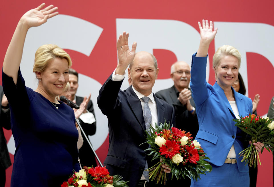 Front from left, Franziska Giffey, top candidate of the SPD for Mayor of the German city of Berlin, Olaf Scholz, top candidate for chancellor of the Social Democratic Party (SPD), and Manuela Schwesig, member of the SPD and governor of the German state of Mecklenburg-Western Pomerania, pose with flowers at the party's headquarter in Berlin, Germany, Monday, Sept. 27, 2021. The center-left Social Democrats have won the biggest share of the vote in Germany's national election. They narrowly beat outgoing Chancellor Angela Merkel's center-right Union bloc in a closely fought race that will determine who succeeds the long-time leader at the helm of Europe's biggest economy. (AP Photo/Michael Sohn)