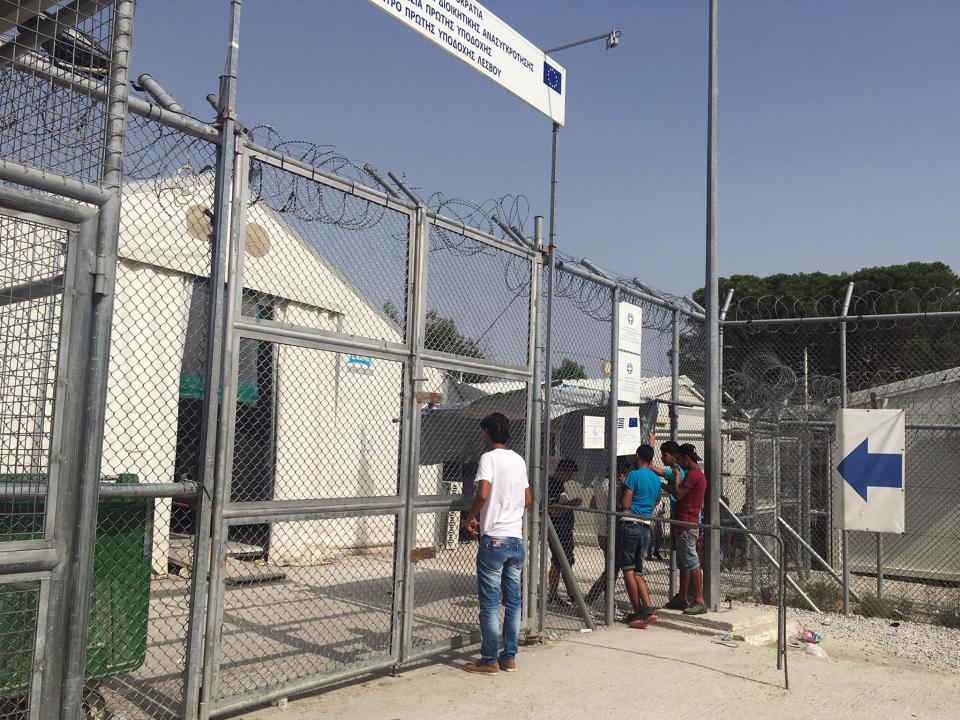 Refugees at the Moria camp on Lesvos wait outside the gates of the on-site detention camp, where others are being held: Janice Dickson