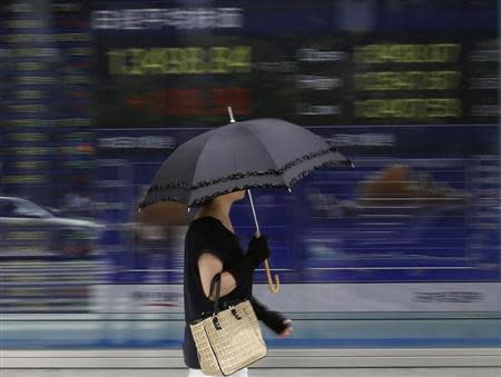 A woman walks past a stock quotation board outside a brokerage in Tokyo September 2, 2013. REUTERS/Toru Hanai