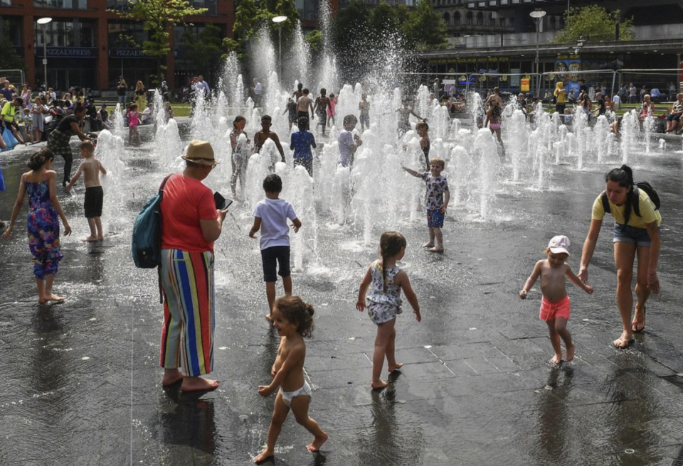 A water fountain at central Manchester gives relief to adults and children on the sweltering day.