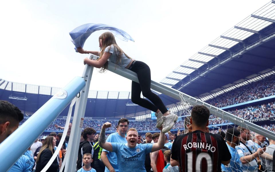 A female Manchester City fan opted to climb onto the crossbar for her celebrations - REUTERS