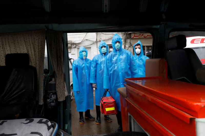 Volunteers of the Edhi Foundation, a non-profit social welfare programme, wear raincoats and boots as they pose during a mock drill on handling suspected carriers of the coronavirus disease (COVID-19), in Karachi, Pakistan