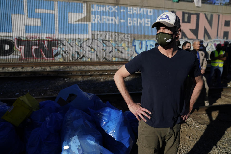 California Governor Gavin Newsom visits a Union Pacific railroad site on Thursday, Jan. 20, 2022, in Los Angeles. Gov. Gavin Newsom on Thursday promised statewide coordination in going after thieves who have been raiding cargo containers aboard trains nearing downtown Los Angeles for months, leaving the tracks blanketed with discarded boxes. (AP Photo/Ashley Landis)