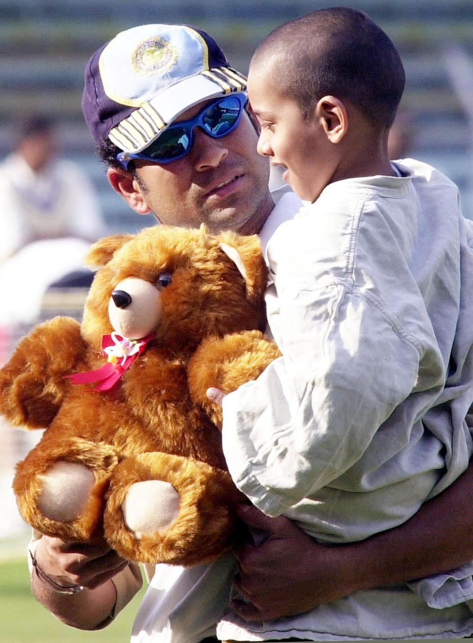 BOMBAY, INDIA: India's star batsman Sachin Tendulkar (L) holds six-year old cancer patient Ganesh Shankar 02 Febuary 2002 at Wankhade Stadium in Bombay. Shankar will undergo major surgery to remove a tumor from behind his right eye. India will play England in the last of six one-day internationals 03 February. AFP PHOTO / Sebastian D'SOUZA (Photo credit should read SEBASTIAN D'SOUZA/AFP/Getty Images)