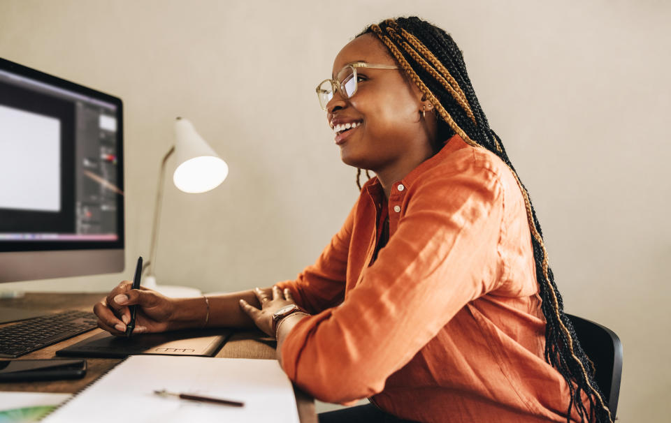 graphic designer working at a computer with a tablet and stylus