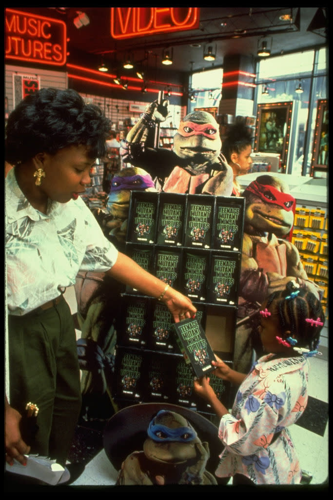 A mother handing her daughter an item