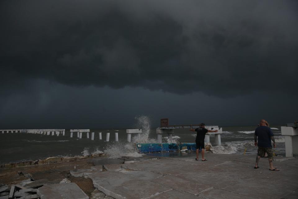 Beachgoers check out the surf as Hurricane Idalia approaches Florida at Times Square on Fort Myers Beach on Tuesday, Aug. 29, 2023.