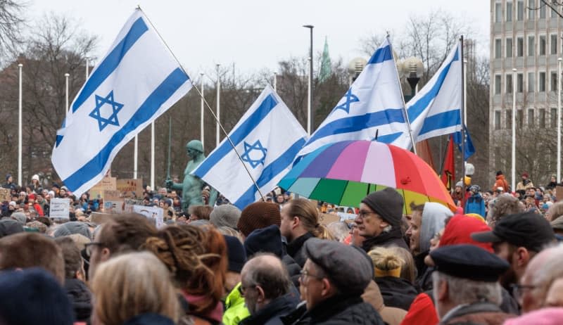 Participants hold Israeli flags at a rally organized by the German Trade Union Confederation (DGB) on "For Democracy and Solidarity". Markus Scholz/dpa