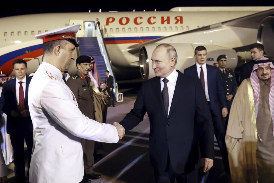 Russian President Vladimir Putin shakes hands with an officer upon his arrival at an international airport in Riyadh, Saudi Arabia, on Wednesday, Dec. 6, 2023. (Konstantin Zavrazhin, Sputnik, Kremlin Pool Photo via AP)