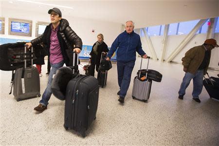 Travelers pull luggage towards check-in counters inside of John F. Kennedy International Airport in New York, November 27, 2013. REUTERS/Lucas Jackson