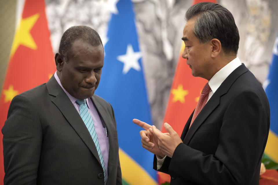 Solomon Islands Foreign Minister Jeremiah Manele, left, and Chinese Foreign Minister Wang Yi talk during a ceremony to mark the establishment of diplomatic relations between the Solomon Islands and China at the Diaoyutai State Guesthouse in Beijing, Saturday, Sept. 21, 2019. (AP Photo/Mark Schiefelbein, Pool)