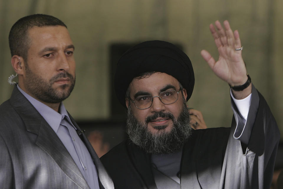 FILE - Hezbollah leader Sayyed Hassan Nasrallah, right, escorted by his bodyguard Yasser Nemr Qranbish, waves to his supporters during a rally, in Beirut's southern suburbs, Lebanon, on Sept. 22, 2006. An Israeli strike in Syria Tuesday July 9, 2024 killed Qranbish, a former personal bodyguard of Hezbollah leader, an official with the Lebanese militant group said. (AP Photo/Hussein Malla, File)