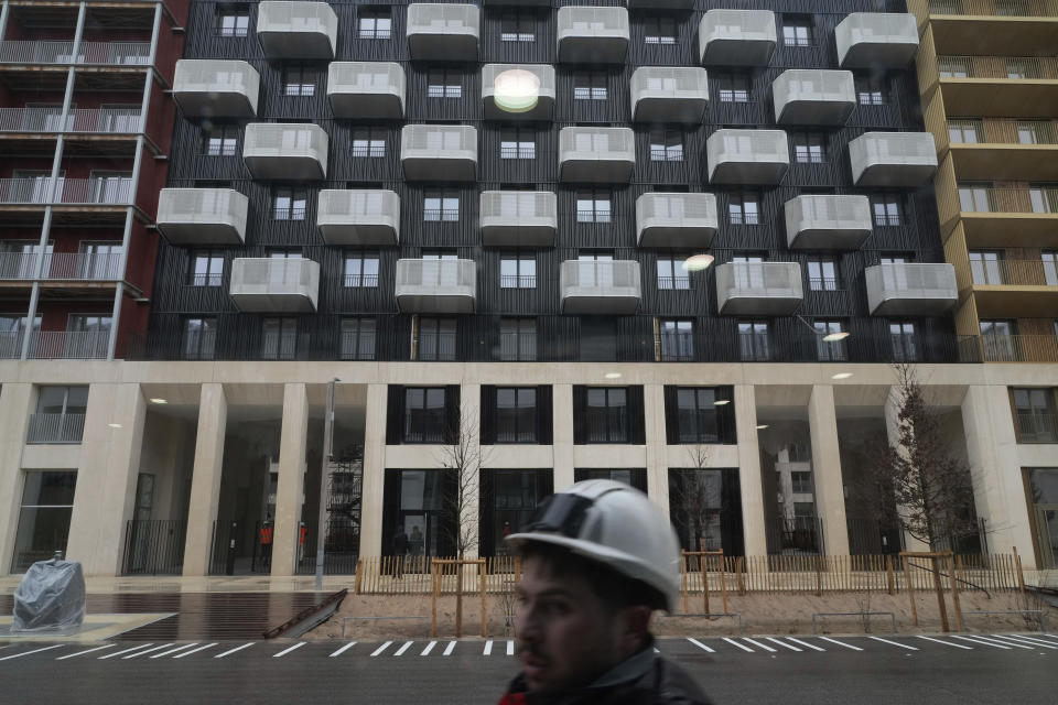 A worker walks in a street of the Olympic village, in Saint-Denis, north of Paris Wednesday, Feb. 28, 2024. When French President Emmanuel Macron inaugurates the Olympic village on Thursday, Feb. 29, he will see a run-down area transformed into an international hub for the Paris Games. (AP Photo/Thibault Camus)