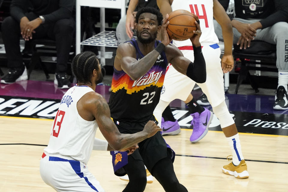 Phoenix Suns center Deandre Ayton (22) shoots as Los Angeles Clippers guard Paul George (13) defends during the first half of game 5 of the NBA basketball Western Conference Finals, Monday, June 28, 2021, in Phoenix. (AP Photo/Matt York)
