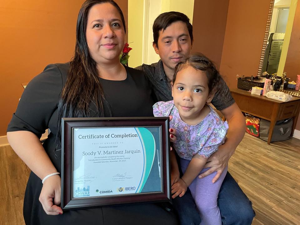 Soody Martinez poses with her husband, Joslyn Berrios, and their 3-year-old daughter, Ashely. She is holding a community health worker certificate she earned. The family came to Rochester in 2023 as asylum-seekers from Nicaragua. "We're going to help others just as we were helped," Martinez said.