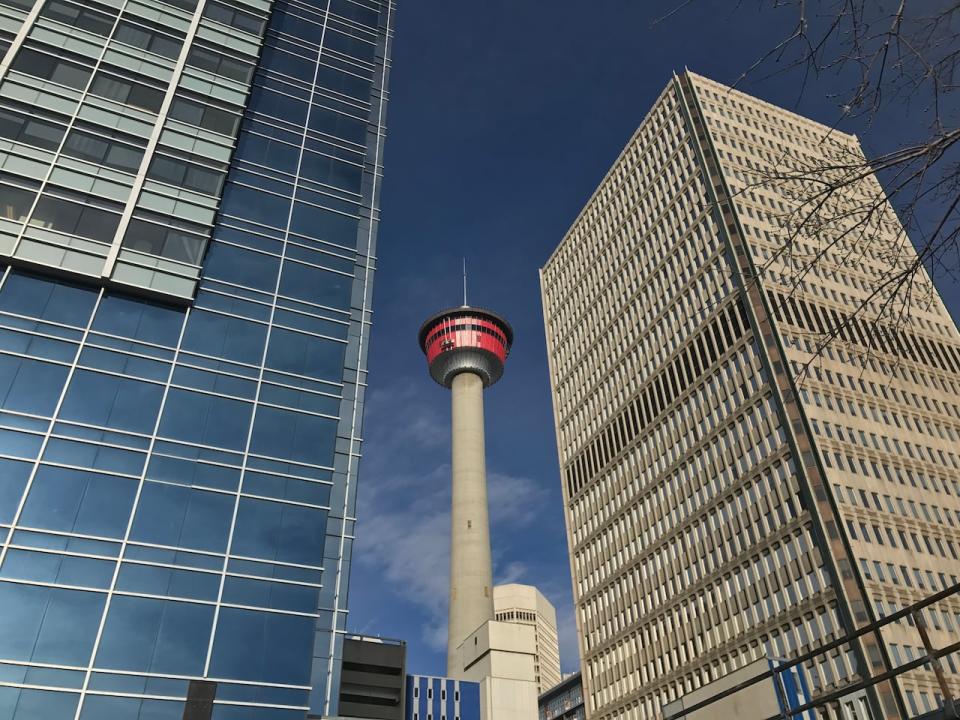 Two office towers appear to dwarf the Calgary Tower (view from ESE) Blue sky bg.