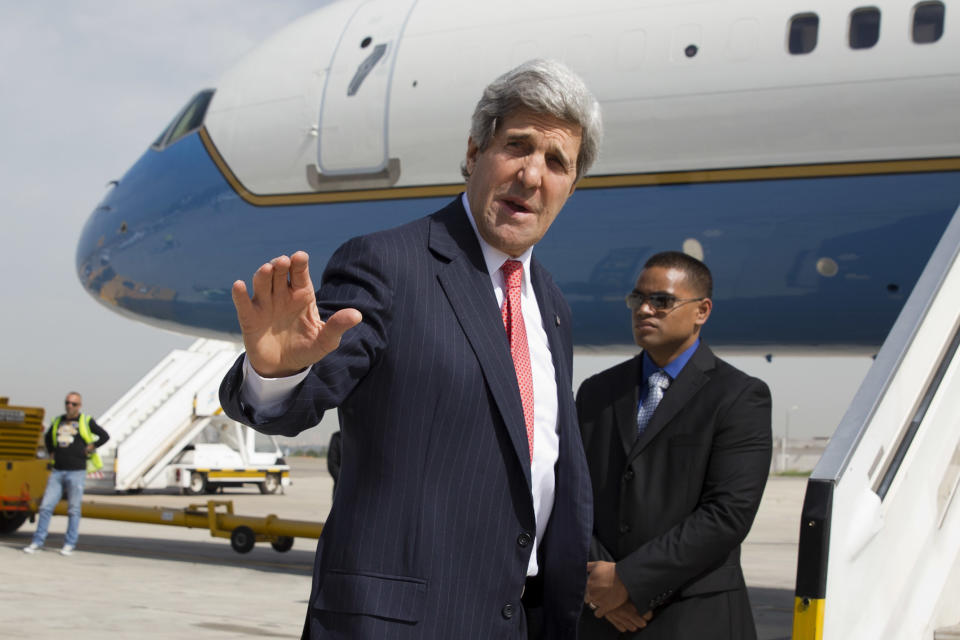 In this April 1, 2014, photo, U.S. Secretary of State John Kerry says goodbye as he leaves Tel Aviv, Israel, continuing on to NATO meetings in Brussels after meeting in Israel with Israeli Prime Minister Benjamin Netanyahu about the Middle East peace process talks. The current trip was to have been a five-day trip to Europe and Saudi Arabia, but with crisis on multiple fronts and Kerry’s decision on how to proceed turned a routine trip abroad into a frenetic tour of high-stakes diplomacy marked by abrupt changes in plan that have come to define his 14-month tenure as secretary of state. (AP Photo/Jacquelyn Martin, Pool)