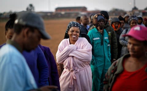 People queue in the early morning cold to cast their votes in the mining settlement of Bekkersdal - Credit: AP Photo/Ben Curtis