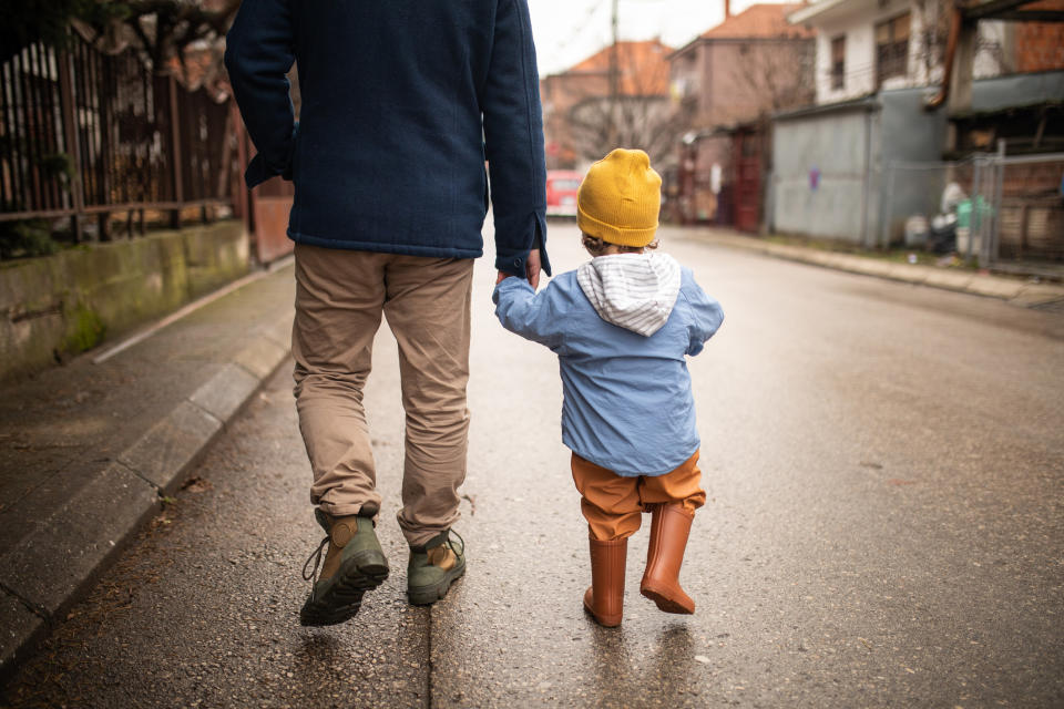 A parent walking with their child down the street