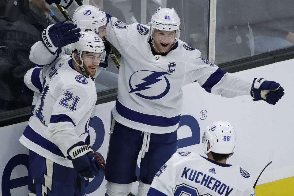 Tampa Bay Lightning center Steven Stamkos (91) celebrates with defenseman Kevin Shattenkirk (22), center Brayden Point (21) and right wing Nikita Kucherov after Shattenkirk scored during the third period of an NHL hockey game against the Boston Bruins, Thursday, Oct. 17, 2019, in Boston. The Lightning won 4-3 in a shootout. (AP Photo/Elise Amendola)