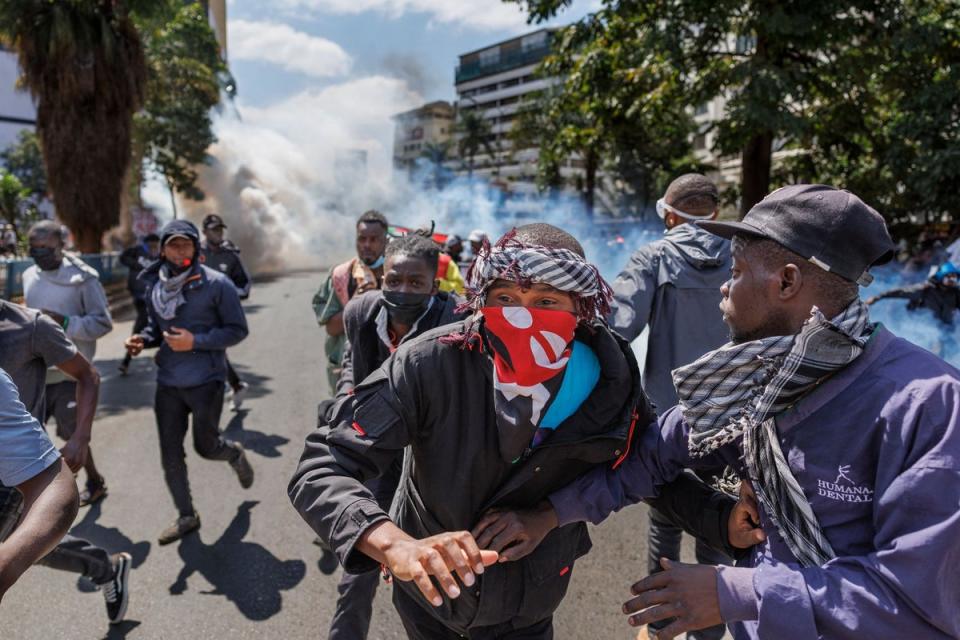 Protesters retreat from a cloud of tear gas (AFP via Getty Images)