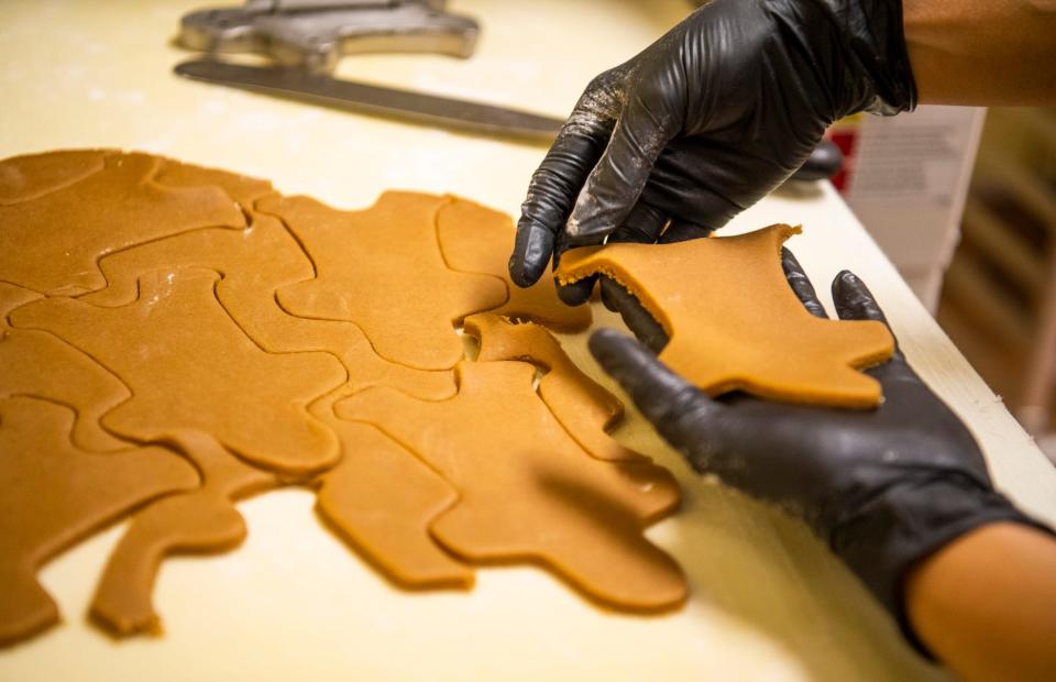 Royce Dcunha makes gingerbread people for a Indiana University themed gingerbread scene at the Indiana Memorial Union on Tuesday, Nov. 29, 2022.