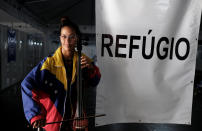 <p>Dulce from Venezuela poses with her instrument after she obtained a refugee status, through the Federal Police and the United Nations High Commissioner for Refugees (UNHCR) at the Pacaraima border control, Roraima state, Brazil, Aug. 9, 2018. (Photo: Nacho Doce/Reuters) </p>