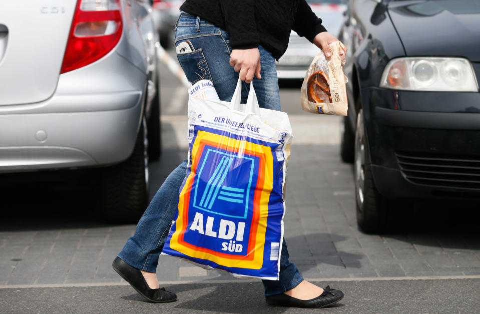 RUESSELSHEIM, GERMANY - APRIL 8:   A shopper carries a bag outside an Aldi store on April 8, 2013 in Ruesselsheim near Frankfurt, Germany. Aldi, which today is among the world’s most successful discount grocery store chains, will soon mark its 100th anniversary and traces its history back to Karl Albrecht, who began selling baked goods in Essen on April 10, 1913 and founded the Aldi name by shortening the phrase Albrecht Discount. His sons Karl Jr. and Theo expanded the chain dramatically, creating 300 stores by 1960 divided between northern and southern Germany, with Aldi Nord and Aldi Sued, respectively. Today the two chains have approximately 4,300 stores nationwide and have also expanded into other countries across Europe and the USA. Aldi Nord operates in the USA under the name Trader Joe’s. (Photo by Ralph Orlowski/Getty Images)