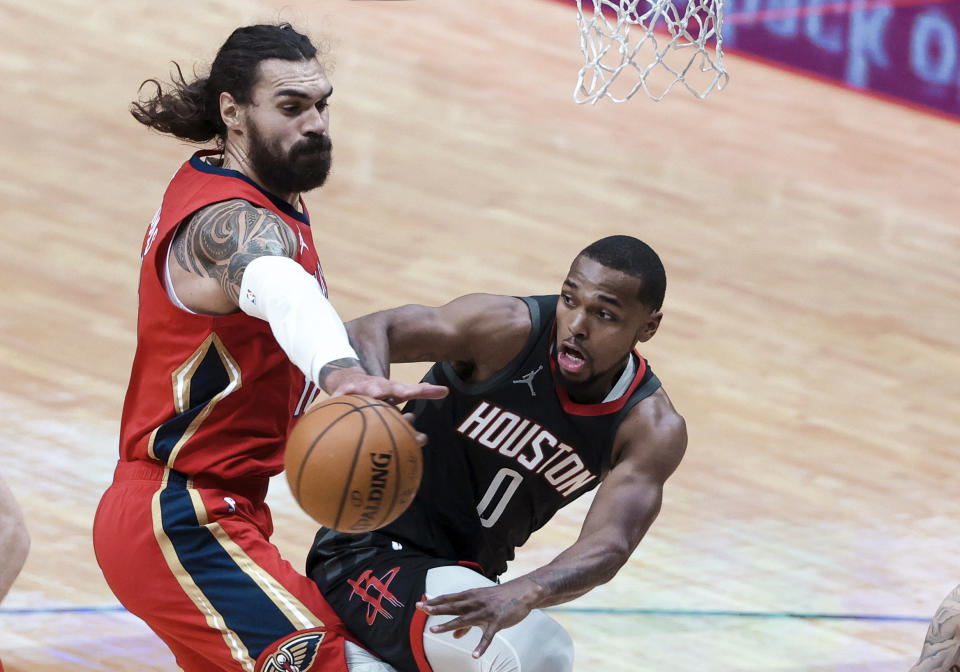 Houston Rockets guard Sterling Brown (0) passes the ball as New Orleans Pelicans center Steven Adams (12) defends during the second quarter of an NBA basketball game in New Orleans, Saturday, Jan. 30, 2021. (AP Photo/Derick Hingle)
