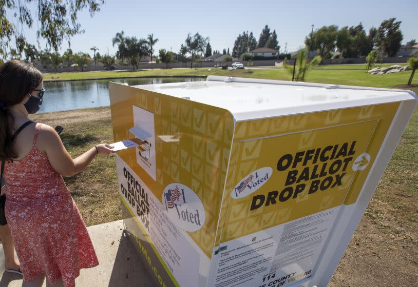 SANTA ANA, CA - OCTOBER 13: Caitlin Harjes, of Orange, places her ballot inside an official Orange County Registrar of Voters ballot Drop Box for the 2020 Presidential General Election at Carl Thornton Park in Santa Ana on Tuesday, Oct. 13, 2020. (Allen J. Schaben / Los Angeles Times)