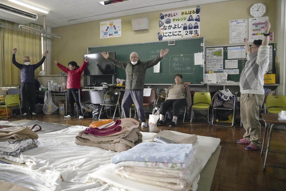 Evacuees exercise at a school turned shelter in Suzu, Ishikawa prefecture, Japan Tuesday, Jan. 9, 2024. Thousands of people made homeless by a powerful earthquake on the western coast of Japan were coping with weariness and uncertainty a week after the temblor. (Kyodo News via AP)