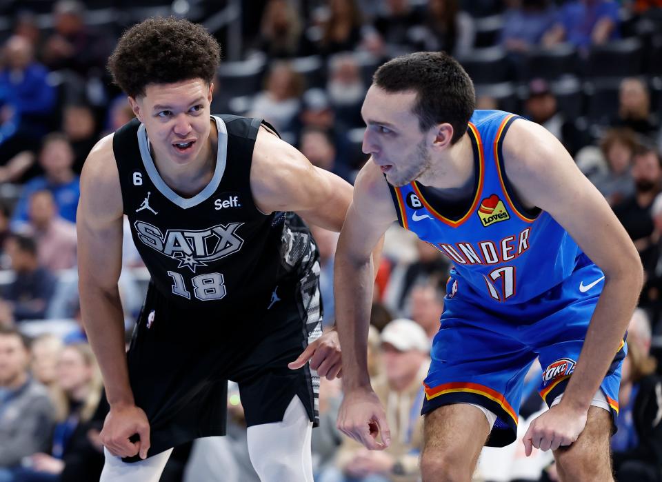 Nov 30, 2022; Oklahoma City, Oklahoma, USA; San Antonio Spurs forward Isaiah Roby (18) and Oklahoma City Thunder forward Aleksej Pokusevski (17) talk during a free throw shot during the second quarter at Paycom Center. Mandatory Credit: Alonzo Adams-USA TODAY Sports