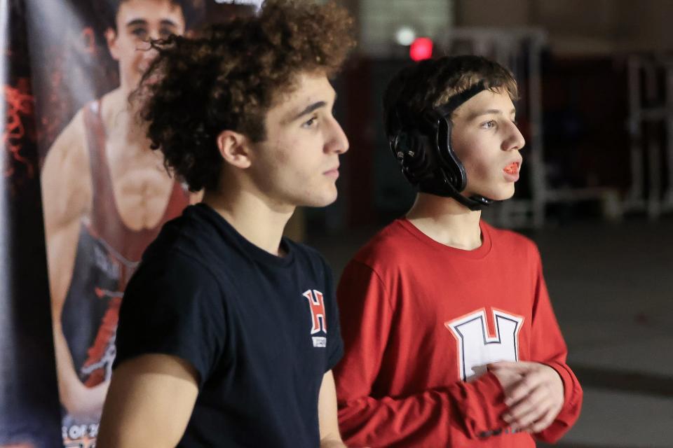 Brothers Zak Robinson (left) and Nate Robinson discuss strategy before Nate's wrestling match against Bellingham at Holliston High School on Jan. 10, 2024.