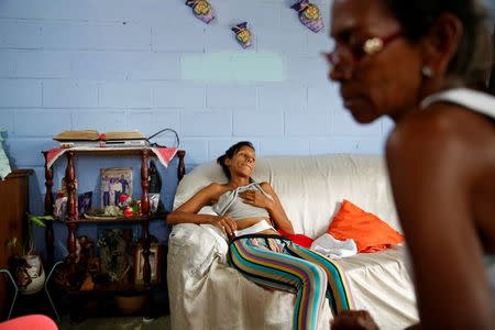 Alejandra Jordan (C), 30, rests on a couch while she recovers after sterilization surgery at her home in San Francisco de Yare, Venezuela July 28, 2016. REUTERS/Carlos Garcia Rawlins