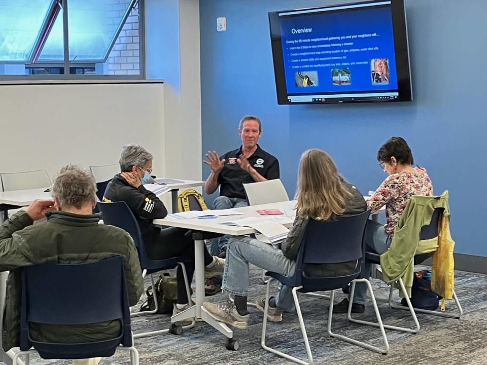 Greg Hope, education and outreach coordinator for the Bellingham Fire Department’s Office of Emergency Management, speaks to library patrons participating in the Map Your Neighborhood program in the Skillshare space at the Bellingham Public Library in an undated handout photo.