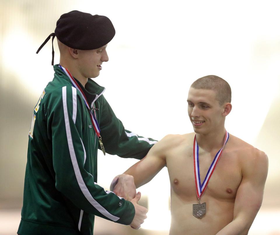 Firestone's Jonny Marshall, left, shakes hands with Toledo St. Francis' Scotty Buff after winning the boys 100-yard backstroke during the Division I state swimming championship at C,T, Branin Natatorium, Saturday, Feb. 26, 2022.