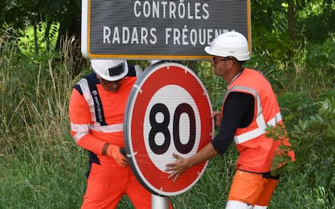 Workers set an 80 kph speed limit sign up on the national road RN2 in Grenade in southwestern France, June 2018. - Credit: &nbsp;PASCAL PAVANI/AFP