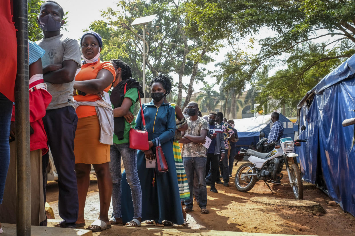 FILE - Ugandans queue to receive Pfizer coronavirus vaccinations at the Kiswa Health Centre III in the Bugolobi neighborhood of Kampala, Uganda Tuesday, Feb. 8, 2022. In the latest Senate package targeted at stopping the coronavirus, U.S. lawmakers dropped nearly all funding for curbing the virus beyond its borders, in a move many health experts describe as dangerously short-sighted. They warn the suspension of COVID aid for poorer countries could ultimately spur the kind of unchecked transmission needed for the next worrisome variant to emerge. (AP Photo/Hajarah Nalwadda, File)