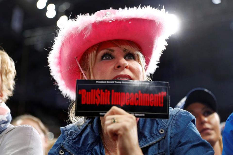 A member of the audience holds up a sticker as Donald Trump speaks in Hershey, Pennsylvania.