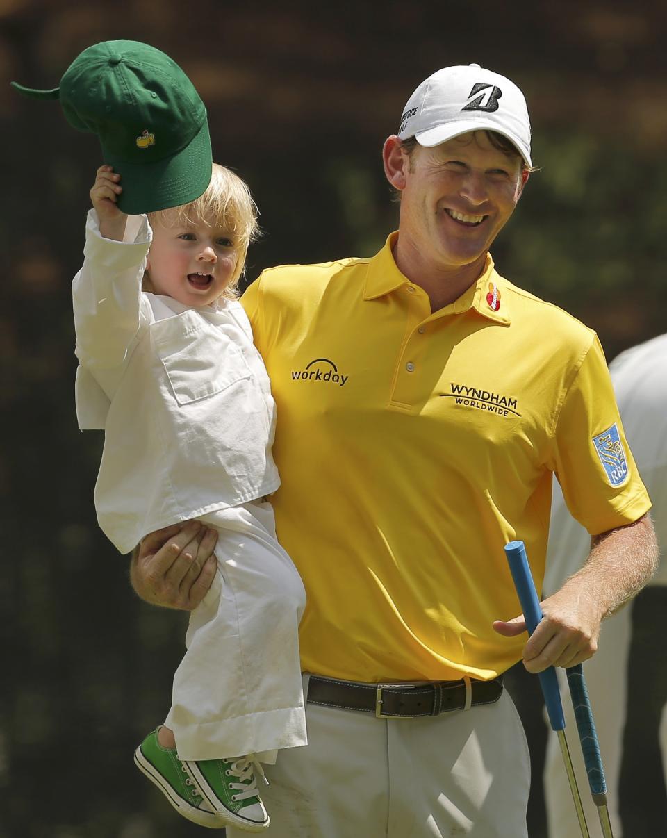 Brandt Snedeker of the U.S. carries his son Austin during the par 3 event held ahead of the 2015 Masters at Augusta National Golf Course in Augusta, Georgia April 8, 2015. REUTERS/Brian Snyder