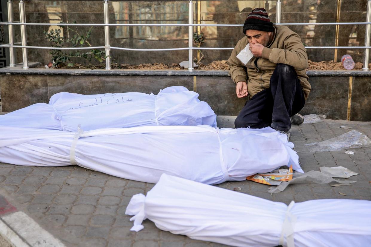 <span>A man mourns at al-Shifa hospital next to bodies of some of the 112 Palestinians killed in Gaza on Thursday.</span><span>Photograph: AFP/Getty Images</span>