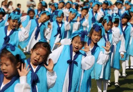 Grade-one children, wearing traditional costumes, attend an entrance ceremony in a primary school in Nantong, Jiangsu province, China, September 16, 2015. REUTERS/China Daily