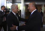 Turkish Foreign Minister Mevlut Cavusoglu, right, and Israeli Foreign Minister Yair Lapid greet each other before their talks, in Ankara, Turkey, Thursday, June 23, 2022. Turkish authorities have detained five Iranian suspected of planning attacks against Israelis, Turkish media reports said Thursday, ahead of a visit to Turkey by Lapid. Lapid met Cavusoglu on Thursday as the two countries press ahead with efforts to repair ties that have been strained over Turkey's strong support for the Palestinians.(AP Photo/Necati Savas, Pool)