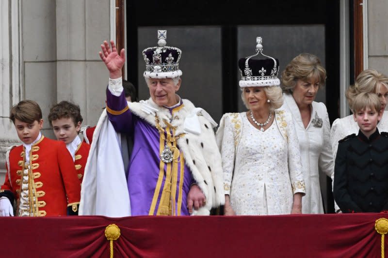 King Charles III and Queen Camilla wave to the public below from the balcony of Buckingham Palace after Charles' coronation at in London on May 6. In his Christmas address on Monday, the king urged protection of both people and the environment. File Photo by Hugo Philpott/UPI