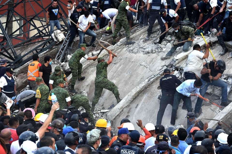Rescuers, firefighters, policemen, soldiers and volunteers remove rubble and debris.