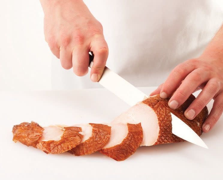 Lay the breast half on the cutting board, skin side up, and bias-cut it into serving-size slices.